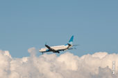 Фото (сбоку, сзади) летящего в небе самолёта Boeing 737 на фоне облаков