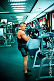 Фото мужчины со штангой в полный рост во время упражнения на бицепс