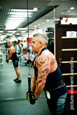 Фото мужчины с татуировкой на руке во время силового упражнения на трицепс