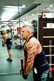 Фото мужчины с татуировкой в тренажерном зале во время тренировки