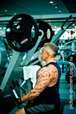 Фото мужчины с татуировкой на руке, сидящего на силовом тренажере Low Row (Pure Strength)