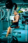 Фото мужчины в полный рост, сидящего на тренажере Low Row Pure Strength во время упражнения тяги к груди