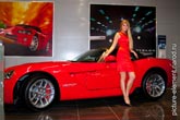 Фото девушки модели в красном платье у двери спортивного купе Dodge Viper
