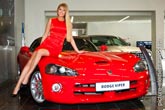 Фото красивой модели, сидящей на красном купе кабриолете Dodge Viper