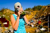 Еще одно фото девушки в противогазе на свалке среди мусора