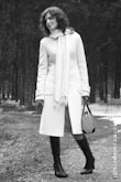 Черно-белое фото девушки в белом пальто в полный рост