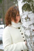 Красивый фото портрет девушки в белом пальто у белой березы