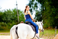 Фото девушки на белой лошади (оборачивающейся назад), вид сзади