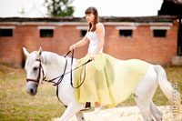 Девушка едет верхом на белой лошади