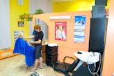 Фото работающего женского парикмахера в интерьере парикмахерской