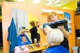 Фото парикмахера с феном и женщины в зеркальном отражении