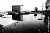 Карелия. Графичный черно-белый фото пейзаж. Деревянные постройки на берегу и их отражения в воде