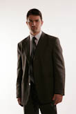 Поясной портрет мужчины-брюнета в деловом костюме на белом фоне
