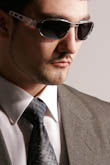 Лицо мужчины в солнечных очках, рубашке, галстуке и костюме