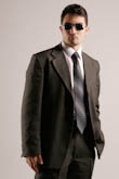 Поясное фото делового мужчины в костюме и солнечных очках