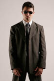 Поясной фотопортрет мужчины в костюме и солнечных очках в фас