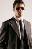 Крутой портрет мужчины в солнечных очках и костюме