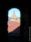 Фото башни и крыш Соловецкого монастыря в оконном проеме
