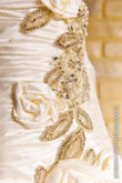 Фото сшитых цветов из ткани и листьев из драгоценных камней на свадебном платье невесты