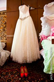 Фото свадебного платья невесты, висящего на шкафу, и туфель невесты, стоящих под платьем