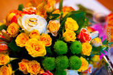 Фото золотых обручальных колец, лежащих на свадебных цветах