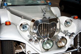 Фото переда старинного свадебного лимузина: радиаторной решетки в форме сердца, фар, труб клаксонов