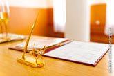 Золотой письменный прибор и книга регистрации брака на столе в ЗАГСе