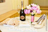 Чулки невесты, обручальные кольца на белой подушке, бутылка Мартини с бокалами, букет и туфли невесты, буквы «Свадьба» на столе
