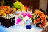 Свадебный натюрморт: открытка-приглашение на свадьбу, коробочка с обручальными кольцами, букет невесты, свадебные бокалы с цветками