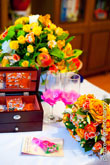 Фото золотых обручальных колец на декоративной свадебной открытке, украшения в шкатулке, бокалы и свадебные цветы