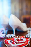 Фото золотых обручальных колец, вдали - туфли невесты в расфокусе