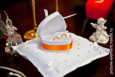 Свадебный фото натюрморт: золотые обручальные кольца в коробочке в форме сердца на белой подушке